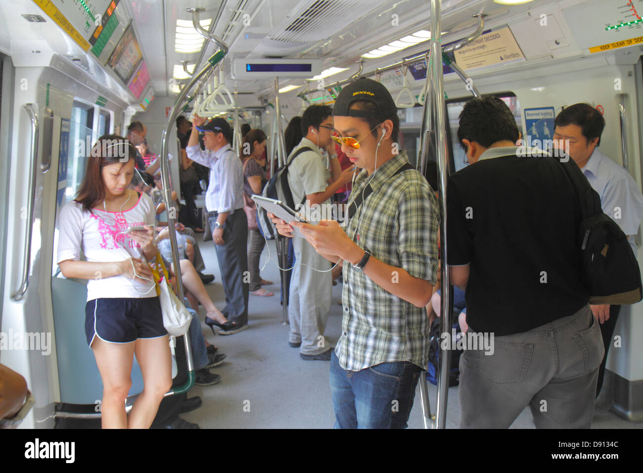Singapore,SMRT,East West Green Line,Tanah Merah Station,mass Rapid Transit,Asian man men maschio,woman femminile,passeggeri passeggeri riders,RID Foto Stock