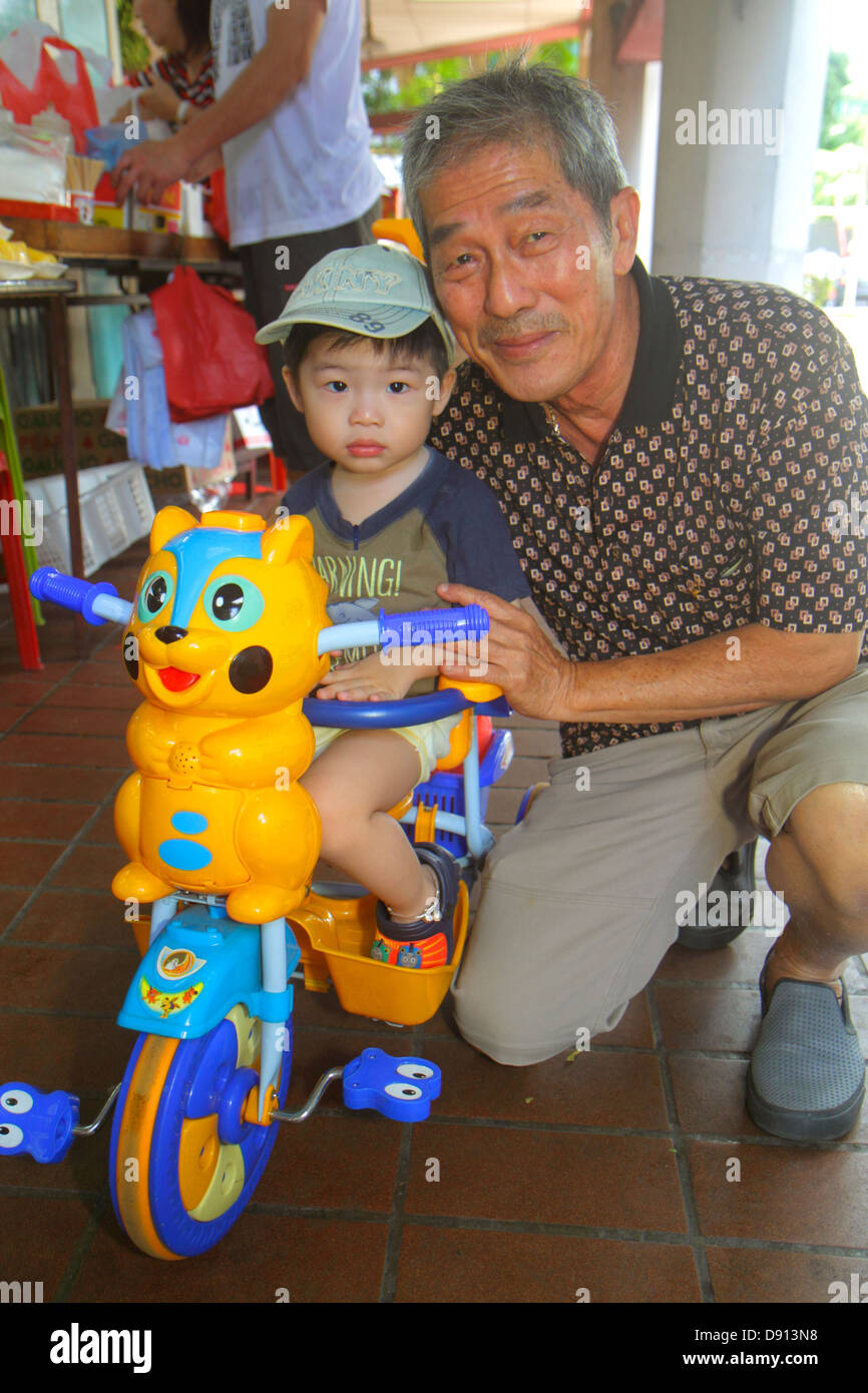 Singapore Kallang Road, uomo asiatico uomini maschio, anziani cittadini cittadini, nonno, papà, ragazzo nipote, triciclo, pedale, Sing130201030 Foto Stock