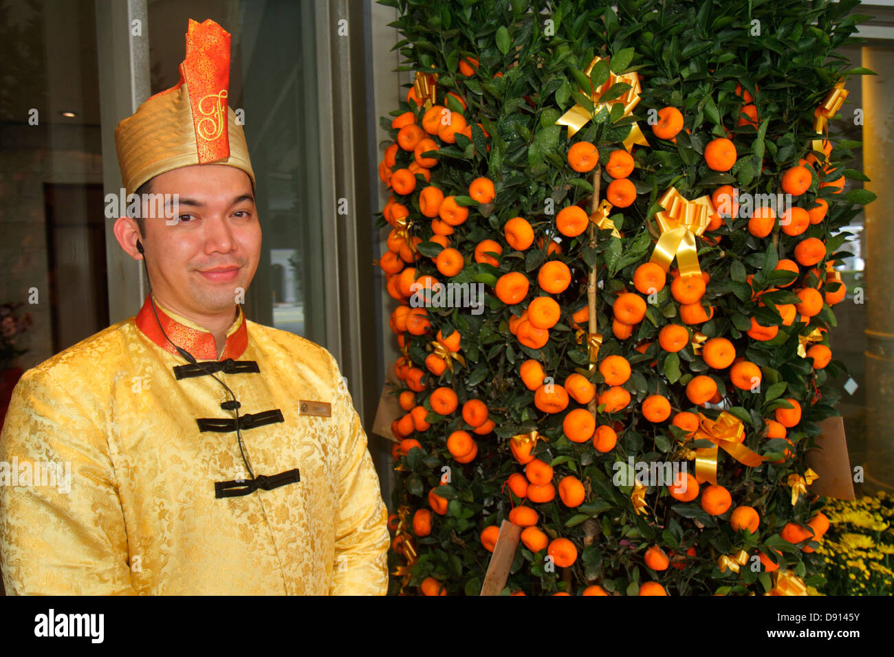 Singapore,Fairmont Singapore,hotel,hall,portiere,uniforme,uomo asiatico maschio,lavoratore dipendente lavoratori dipendenti staff di lavoro,albero d'arancia mandarino,mandarino,mandarino,Chine Foto Stock