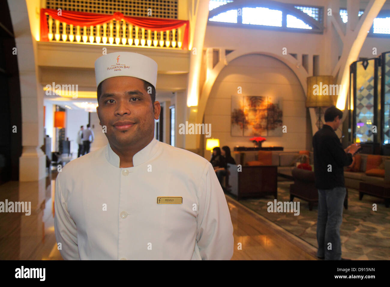 Singapore,The Fullerton Bay,hotel,portiere,lobby,uomo asiatico maschio,lavoratore dipendente lavoratori dipendenti personale di lavoro,lavoro,uniforme,interno,Sing1302 Foto Stock
