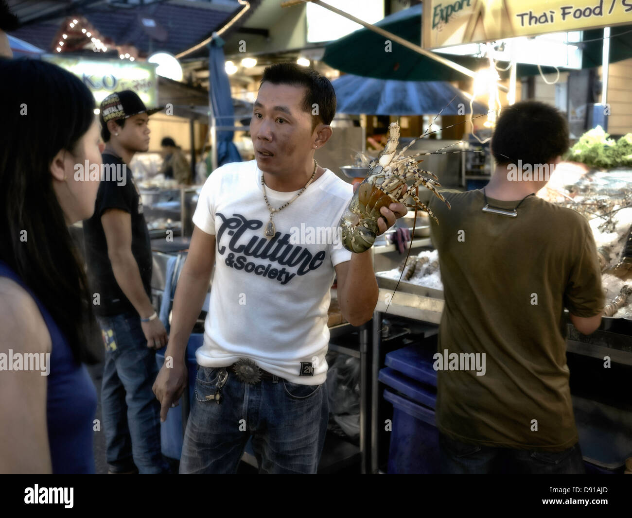 Thailandia Night Market street food fornitore che offre astice a un potenziale cliente. Hua Hin mercato di frutti di mare. Thailandia SUDEST ASIATICO Foto Stock