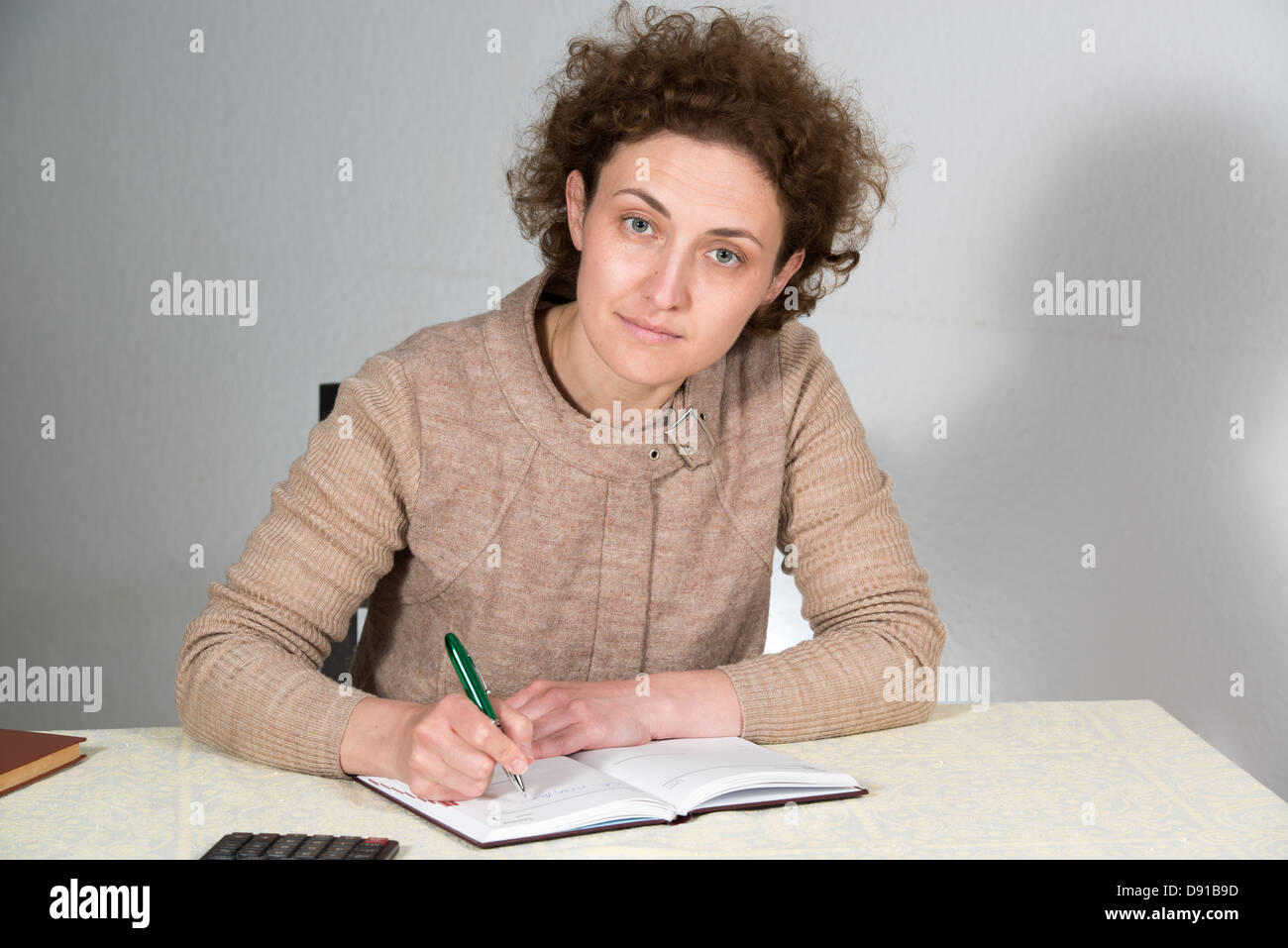 Giovane donna ricci lavora come contabile (ragioniere) Foto Stock