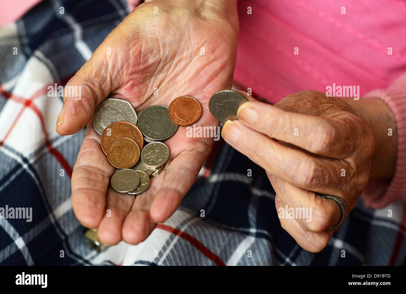 Soldi, monete in una donna anziana con le mani in mano, close up di denaro contante nelle mani della donna anziana Foto Stock