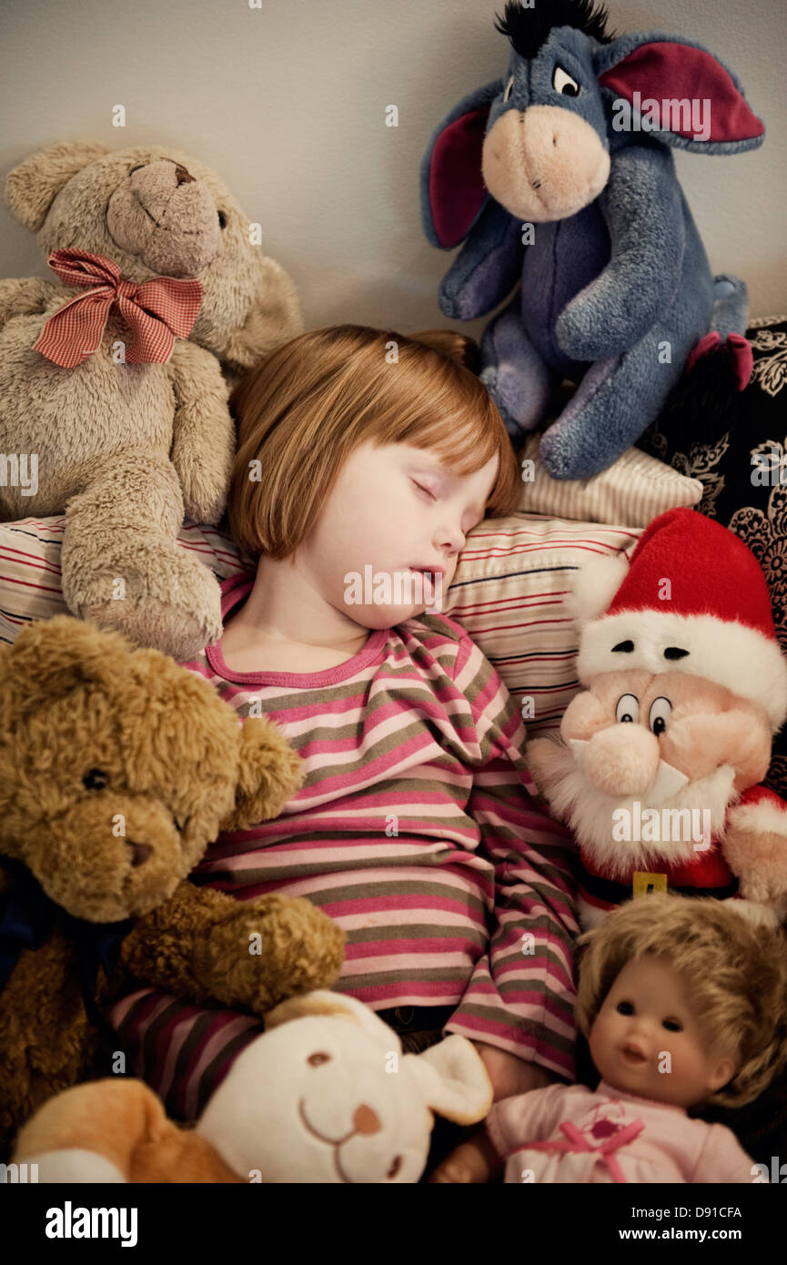 Ragazza dorme tra peluche, Svezia. Foto Stock