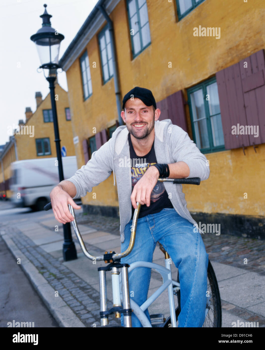 Un uomo su una moto di fronte a una casa, Danimarca. Foto Stock