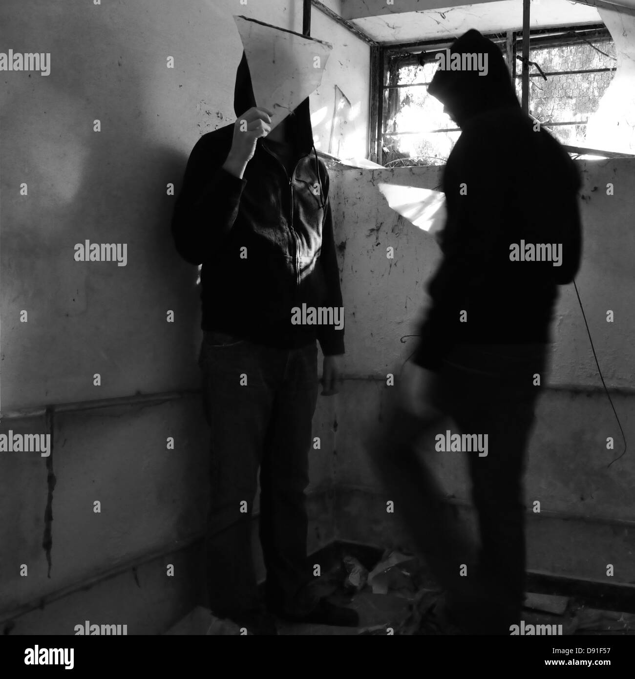 Uomo con frammento di vetro e sfocata figura con luce solare riflessa dal vetro rotto. In bianco e nero. Foto Stock