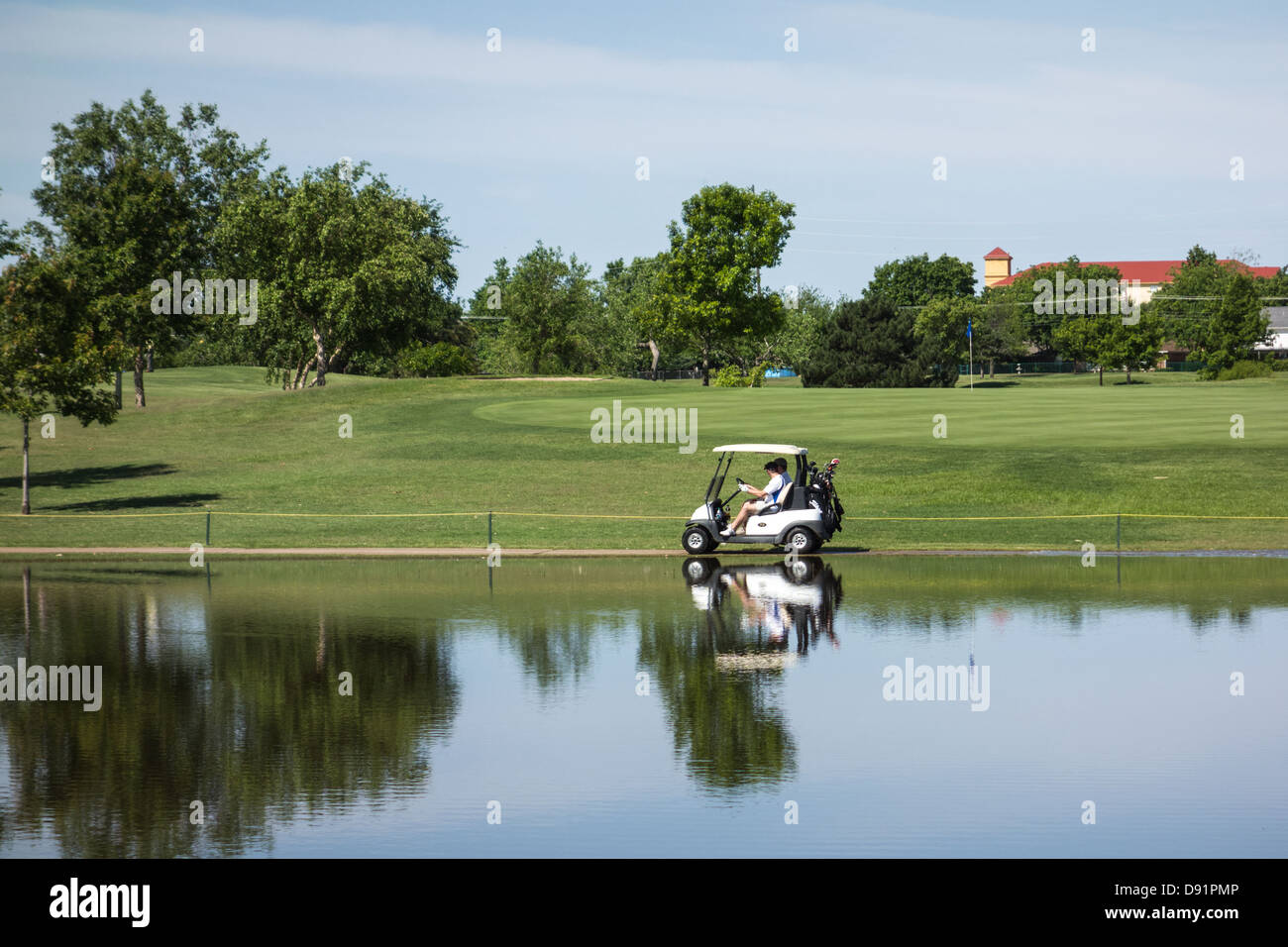 Due amanti del golf in un golf cart per seguire il sentiero del carrello al Lago Hefner Collaboratore Domestico Corso, Oklahoma City, Oklahoma, Stati Uniti d'America. Foto Stock
