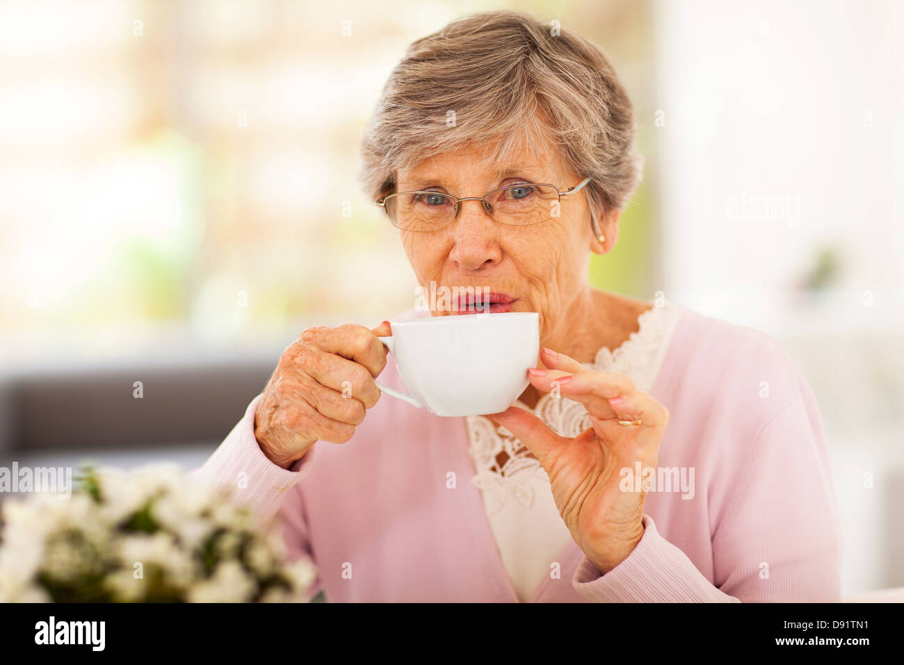 Senior donna bere il tè a casa Foto Stock