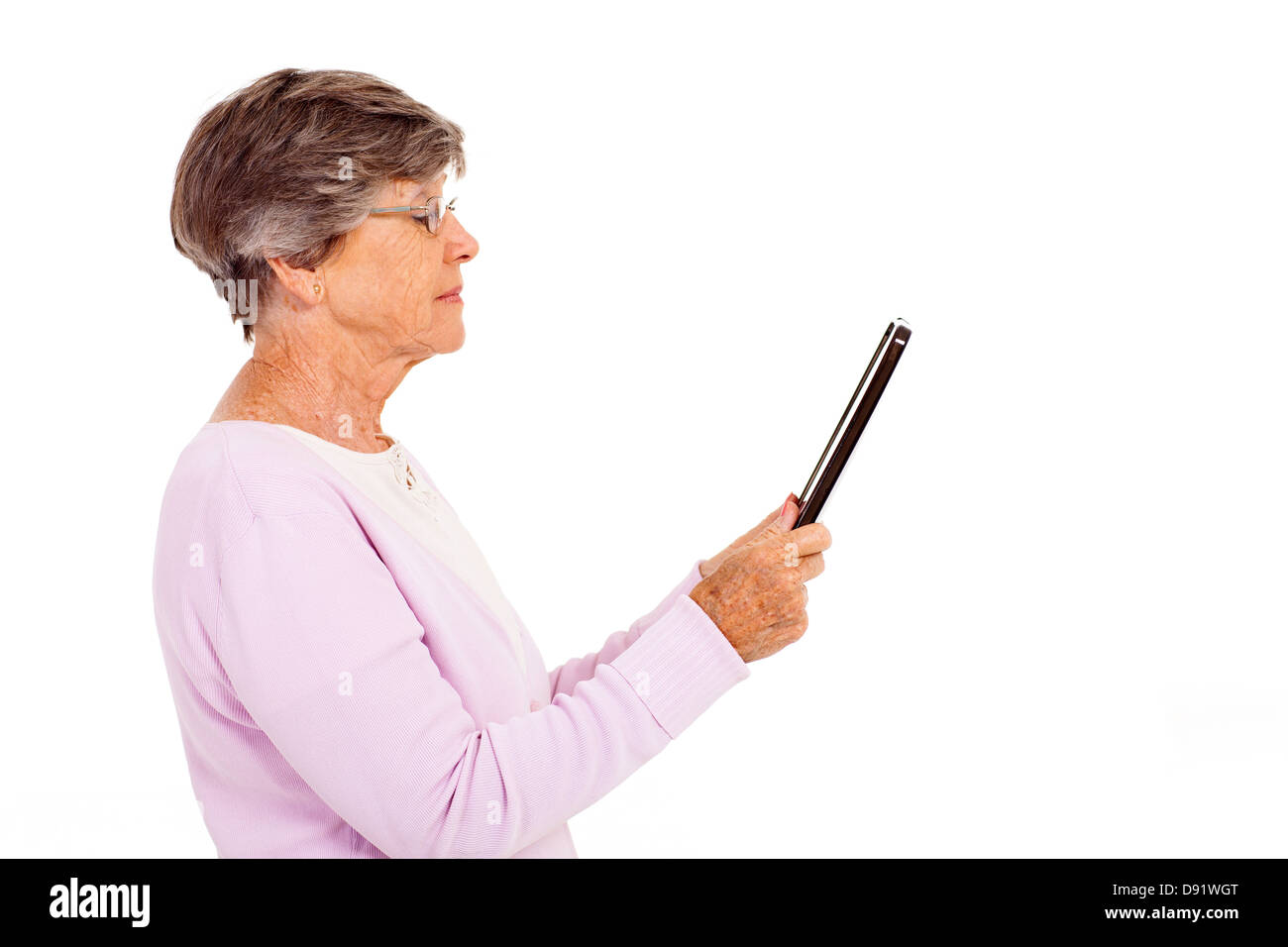 Donna anziana la lettura di un libro sul computer tablet isolato su bianco Foto Stock