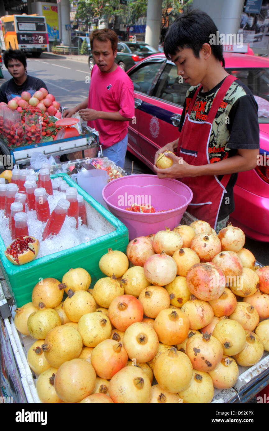 Thailandia,Thai,Bangkok,Silom,Silom Road,strada,venditori ambulanti,bancarelle stand mercato,melograno,succhi di frutta,bevande,cibo,uomo asiatico maschio,j Foto Stock