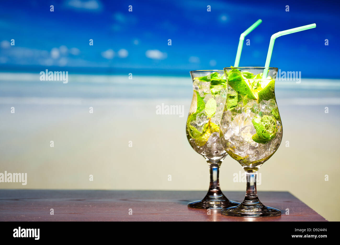 Cocktail Mojito con lime e menta su una spiaggia in background Foto Stock