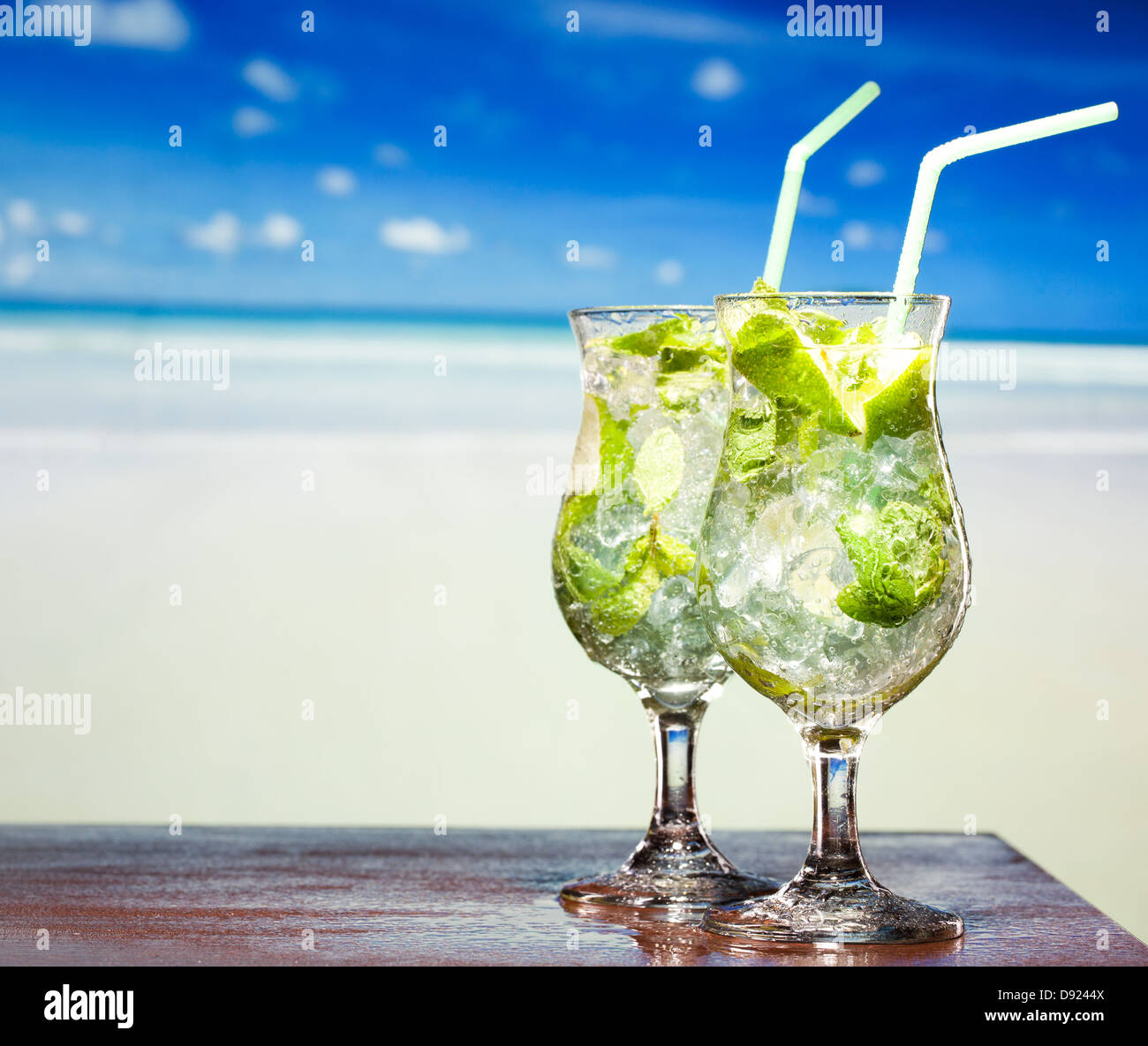 Cocktail Mojito con lime e menta su una spiaggia in background Foto Stock