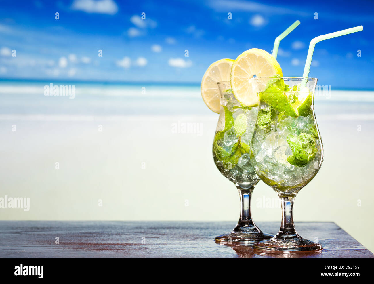 Cocktail Mojito con lime e menta su una spiaggia in background Foto Stock
