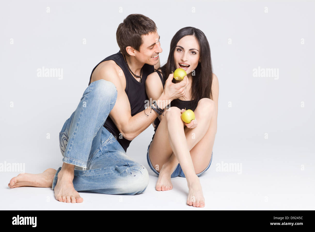 Coppia felice di mangiare le mele e ridere, studio shot Foto Stock