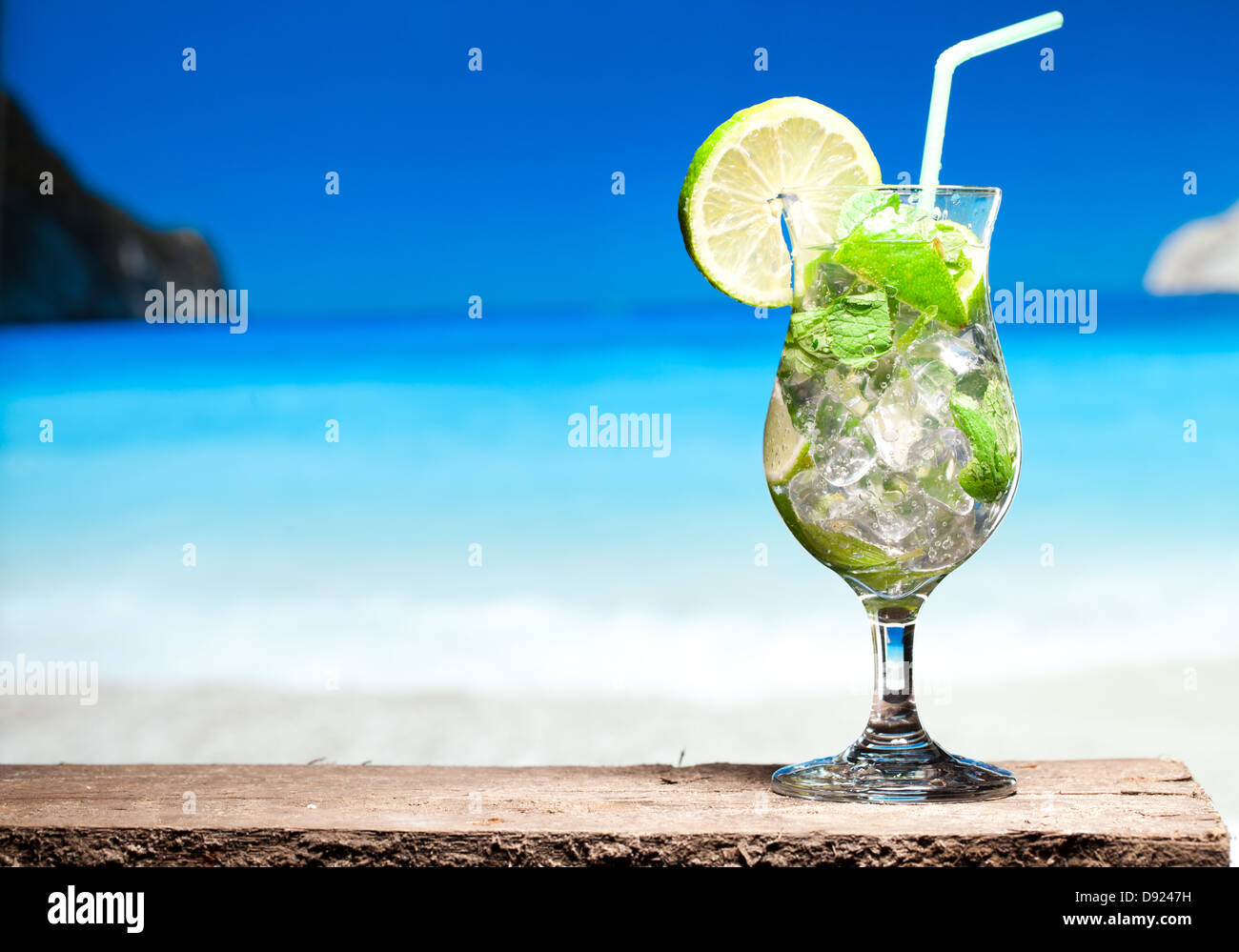 Cocktail Mojito con lime e menta su una spiaggia in background Foto Stock