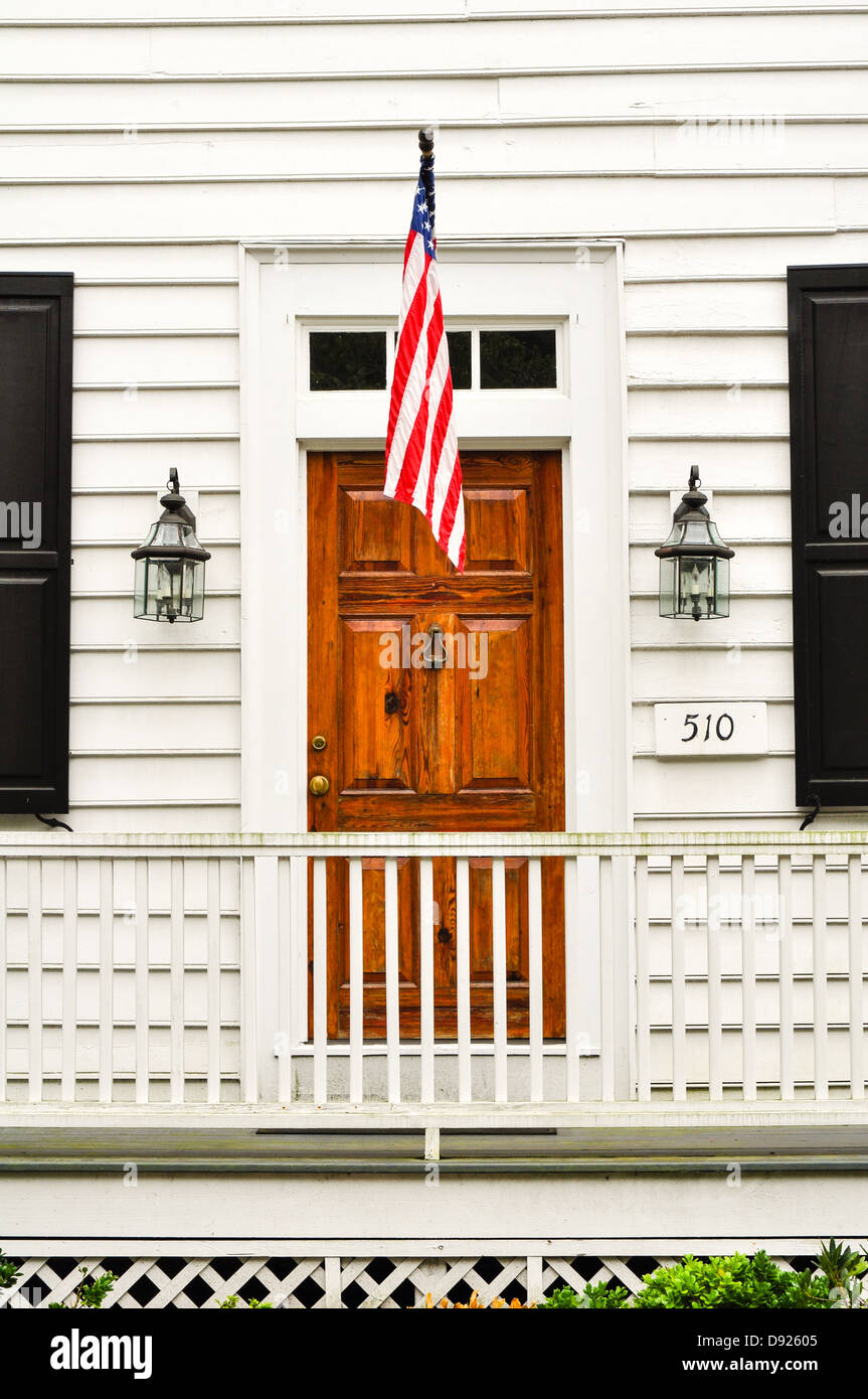 Brown porta di legno con una bandiera statunitense in un bianco parete in legno Foto Stock