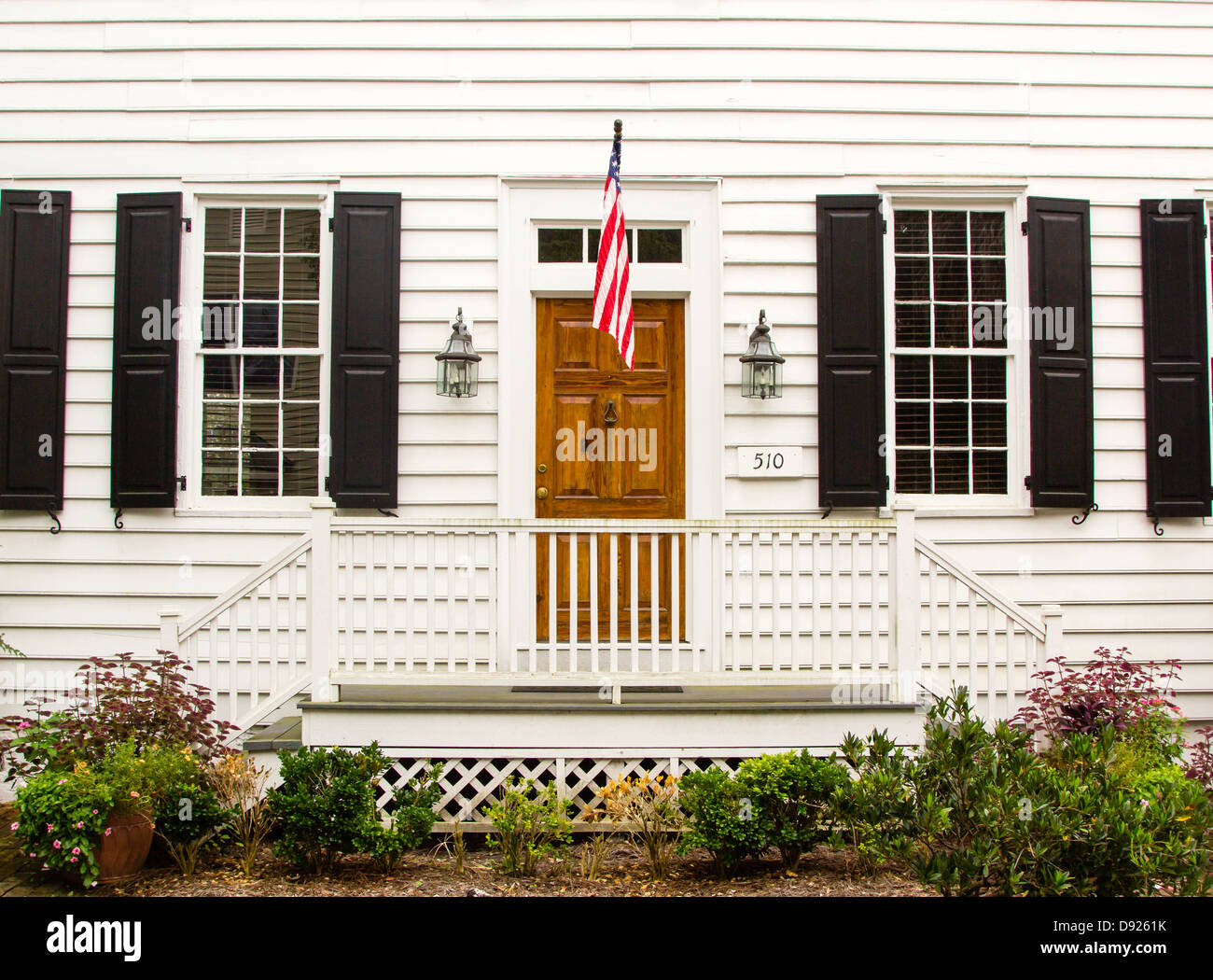 Brown porta di legno con una bandiera statunitense in un bianco parete in legno Foto Stock