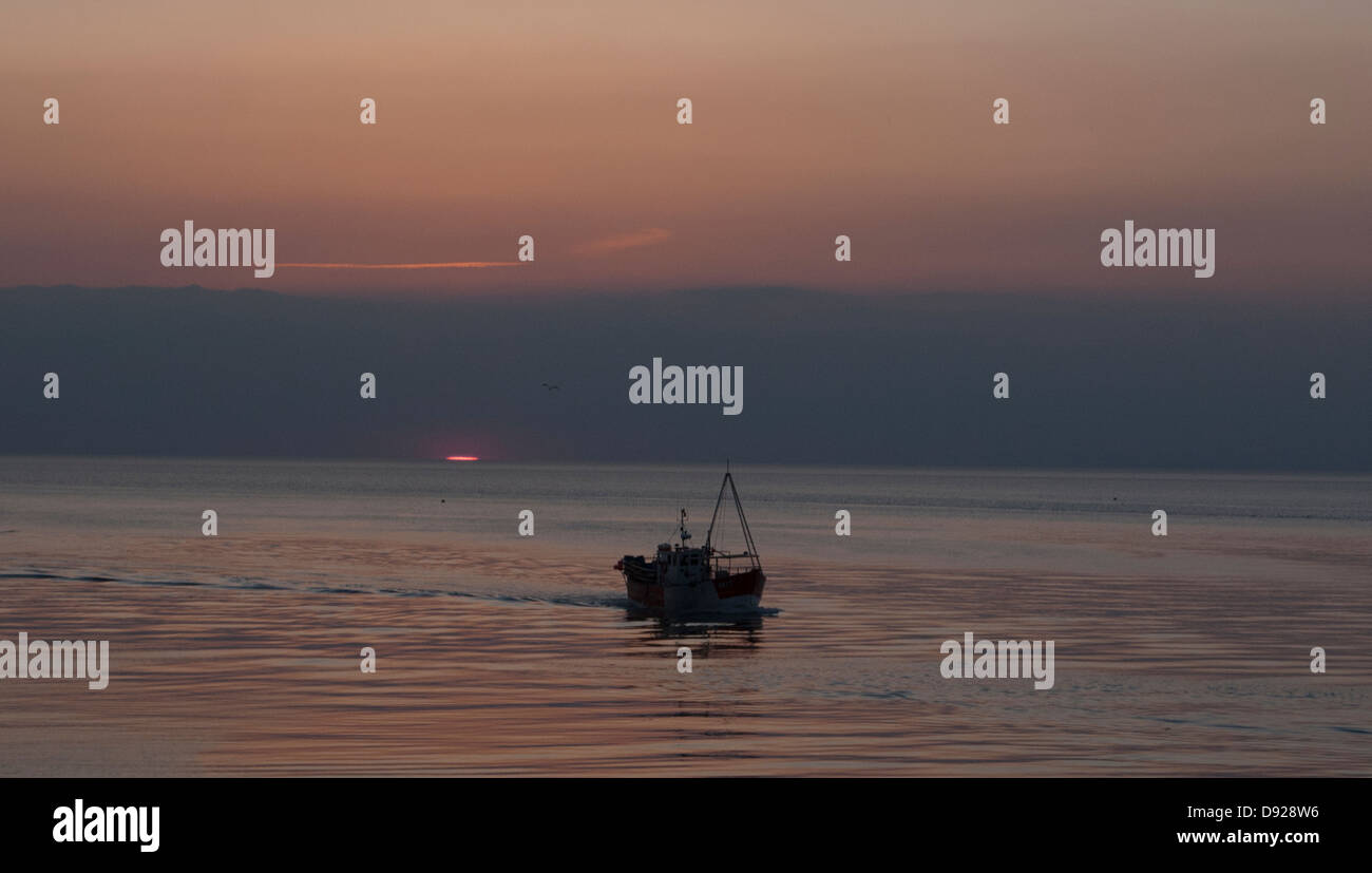 Trawler sul mare al tramonto. Foto Stock