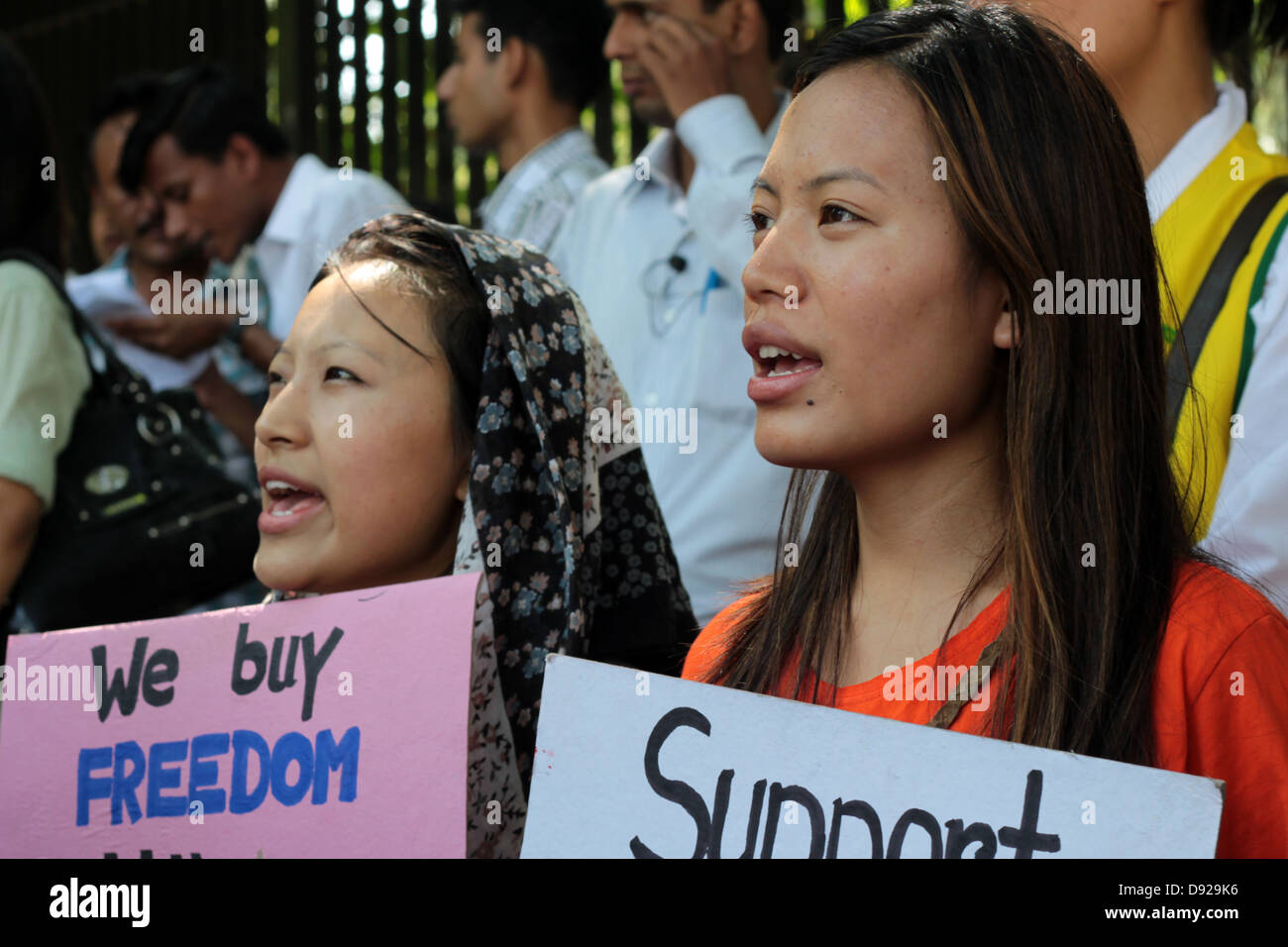 Ragazze tibetana protesta e tenere i cartelli in New Delhi, India, condannando l'occupazione cinese del Tibet. Foto Stock
