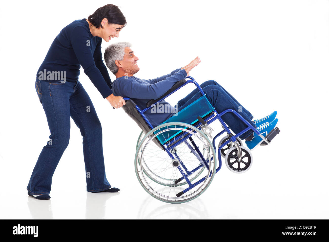 Felice Coppia matura per divertirsi con sedia a rotelle isolati su sfondo bianco Foto Stock