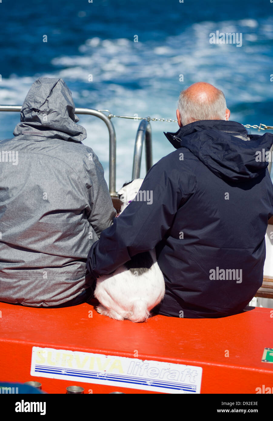 Una coppia di anziani e il loro cane godendo di una crociera in barca mentre è in vacanza in Cornovaglia, England, Regno Unito Foto Stock