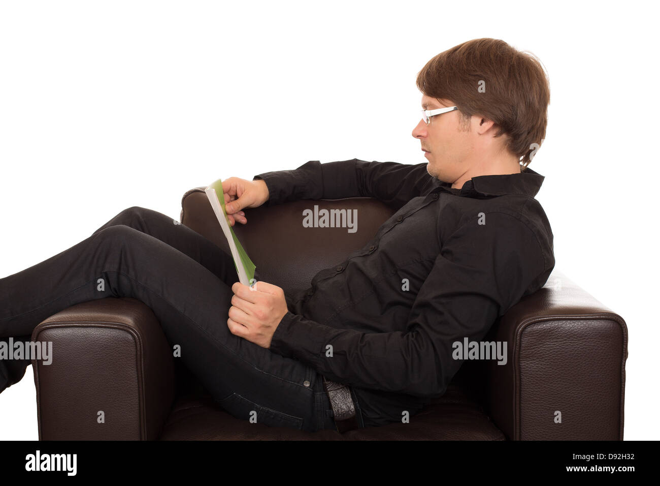 Uomo con occhiali o leggere un libro in silenzio nella sua pelle marrone progettato poltrona. Isolato su sfondo bianco. Foto Stock