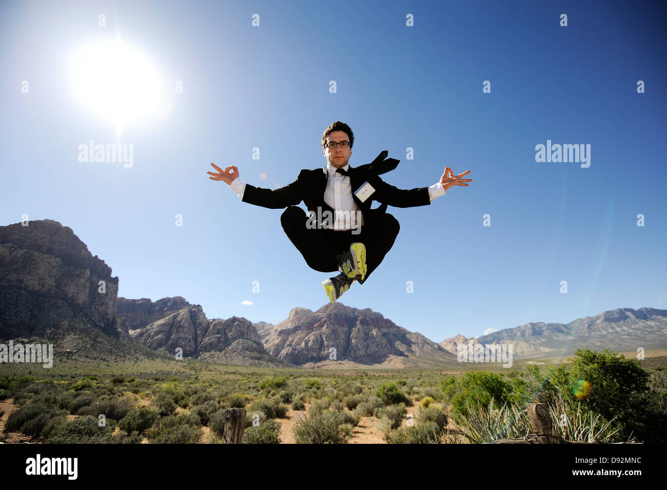Un uomo in abito nero e cravatta facendo yoga posa Zen galleggiante sopra  il deserto con calma come se congelati nel tempo, arroccato sulla montagna  Foto stock - Alamy