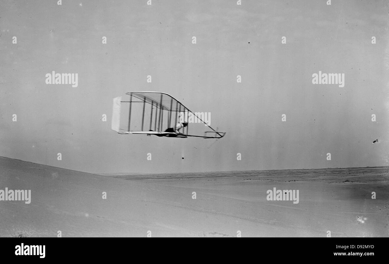 Vista laterale di Wilbur Wright in deltaplano in volo livellato spostando a destra vicino al fondo di Big Hill; Kitty Hawk, Carolina del Nord Foto Stock