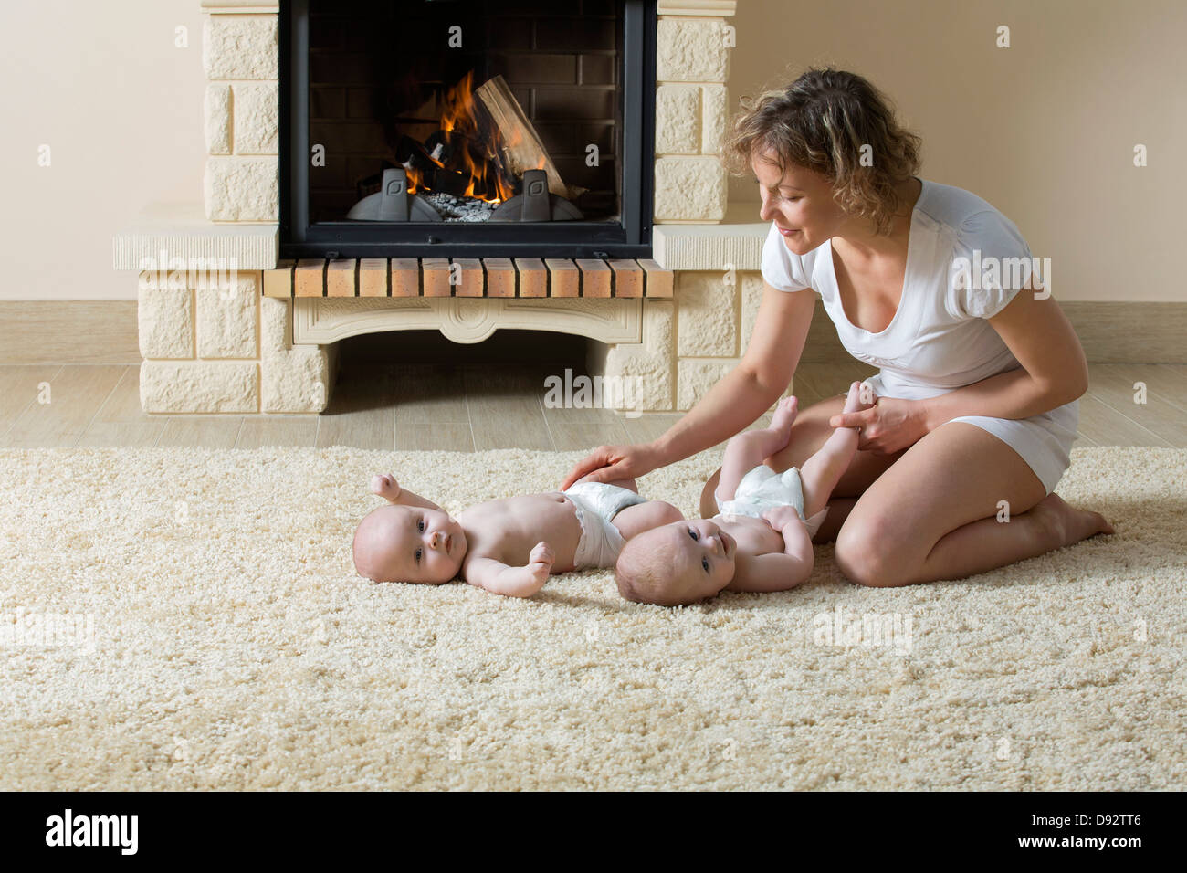 La madre e le figlie sul tappetino nella parte anteriore del fuoco Foto Stock