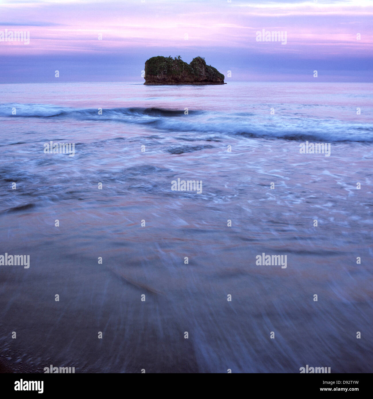 Seascape e isola sotto un cielo di tramonto Foto Stock