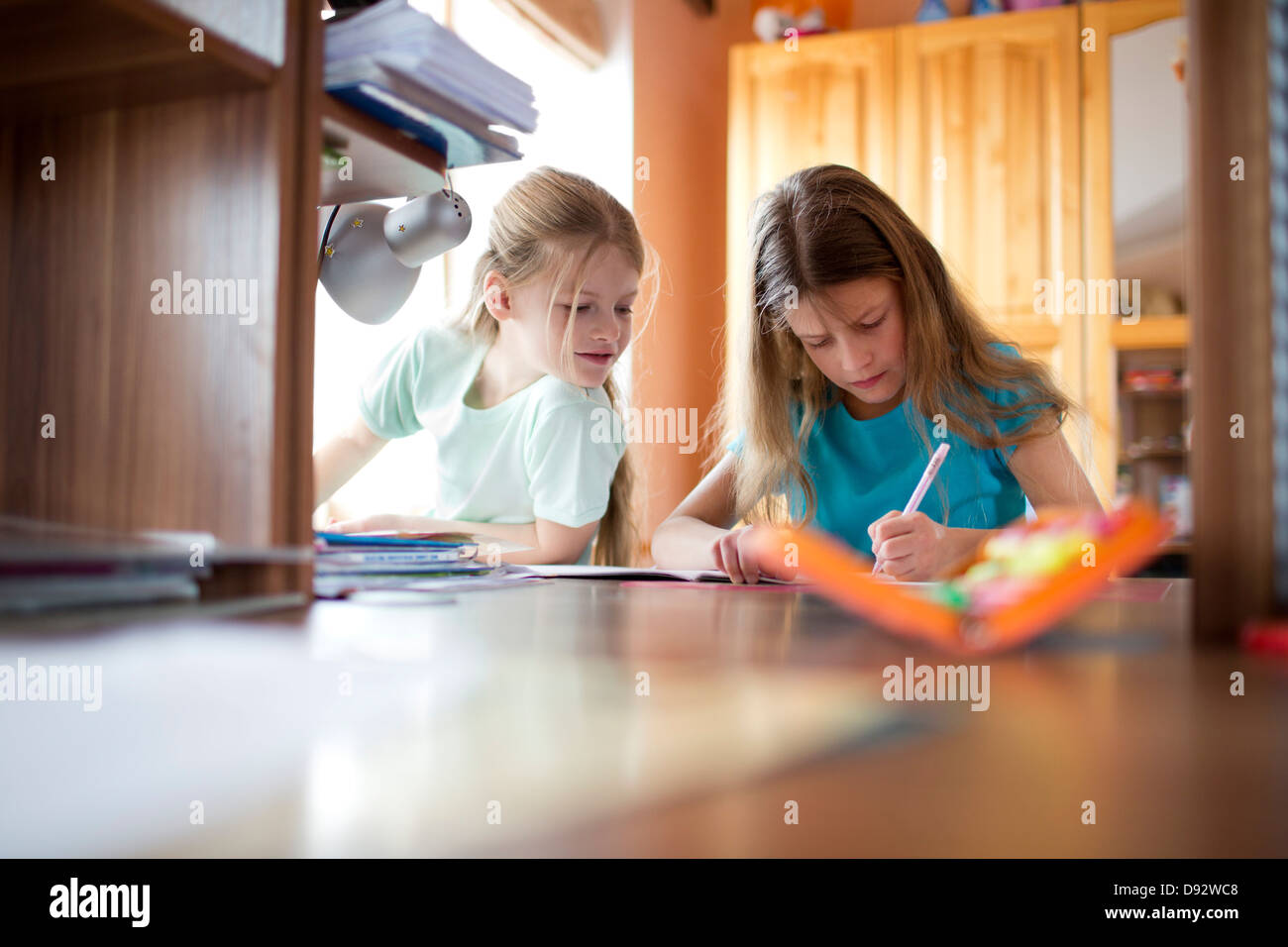 Due sorelle facendo i compiti di scuola Foto Stock