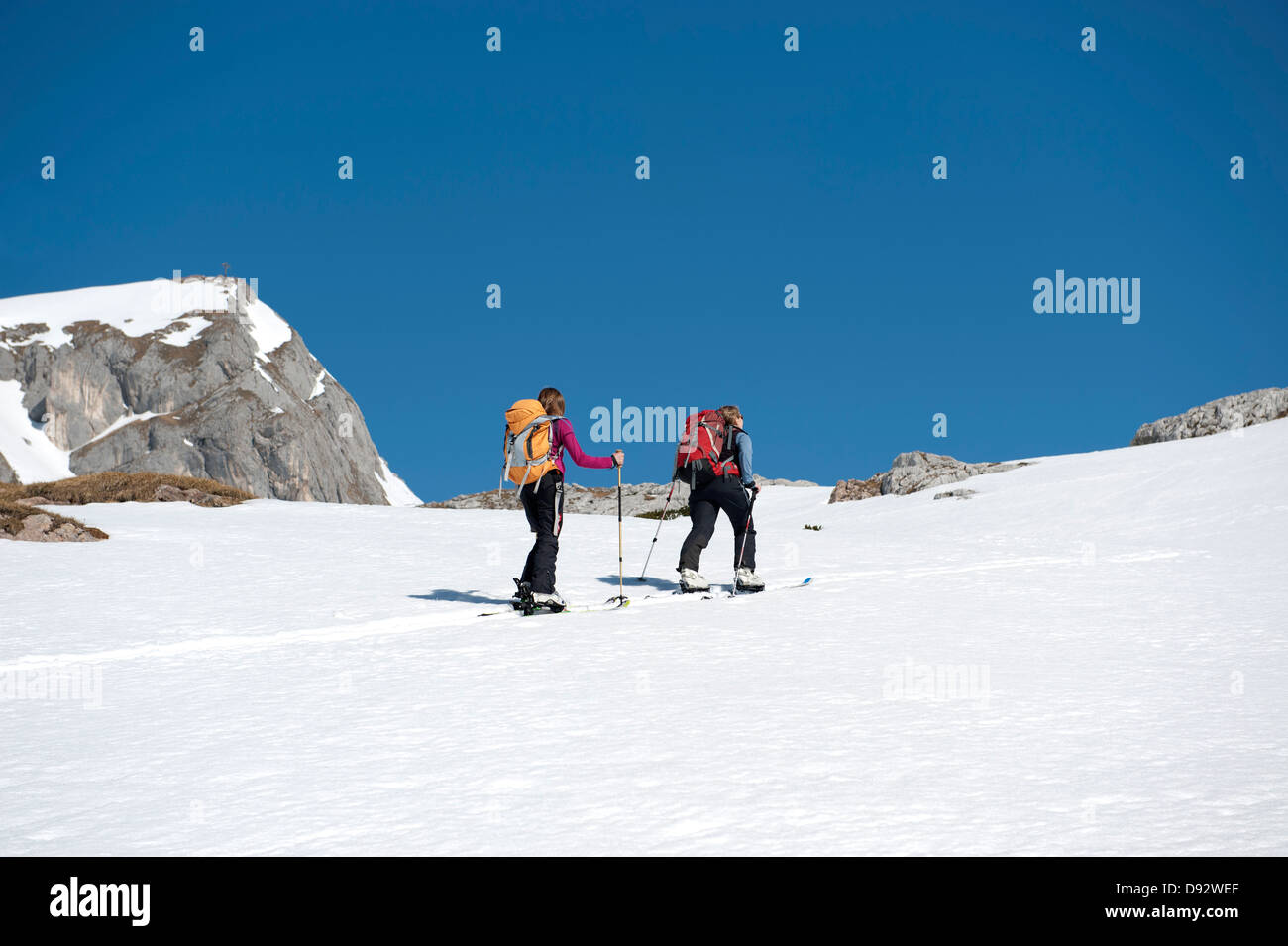 Due gli sciatori nello spostamento verso l'alto di un colle nevoso sulle Dolomiti, Alto Adige, Italia, Foto Stock