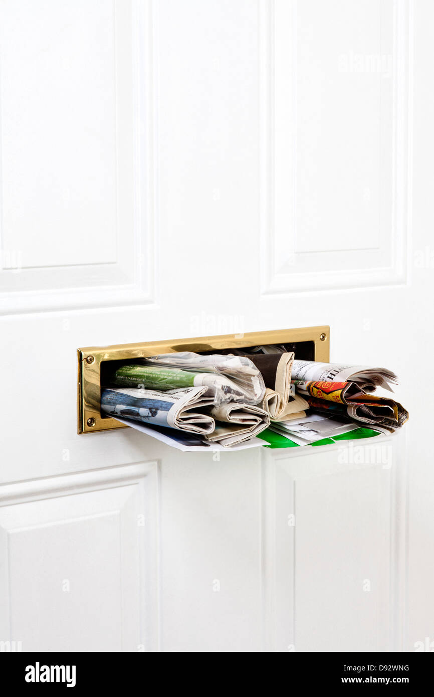 Un mail slot farcite con mail e quotidiani, close-up Foto Stock