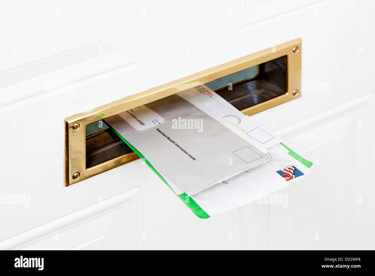 Molti pezzi di messaggi di posta elettronica bloccati in una porta anteriore mail slot, close-up Foto Stock