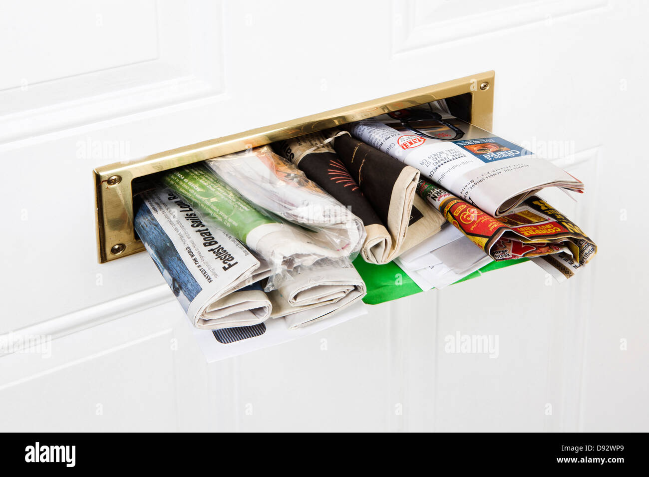 Un mail slot farcite con mail e quotidiani, close-up Foto Stock