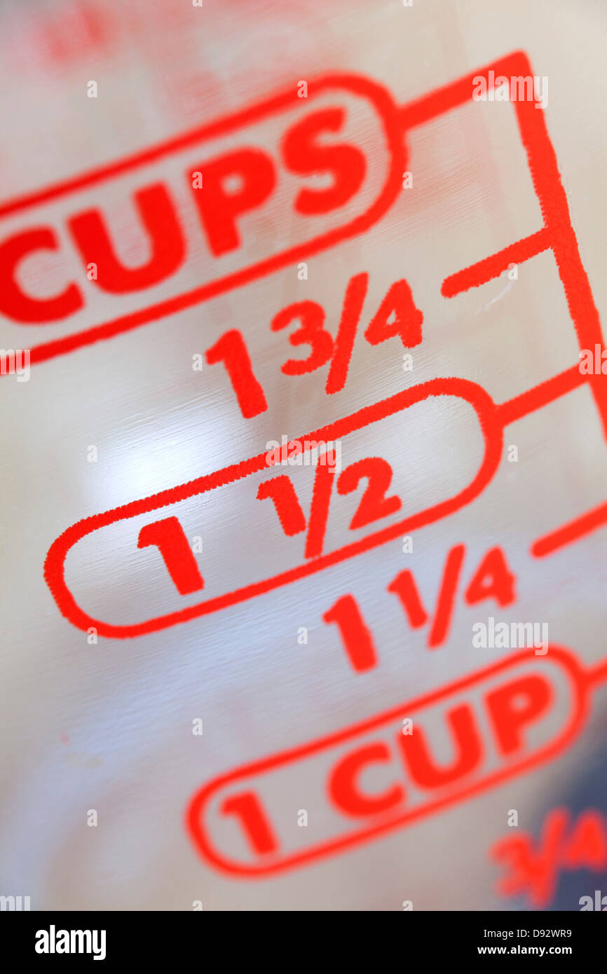 Le misurazioni di frazione sul lato di liquido di una coppa di misurazione, extreme close up Foto Stock