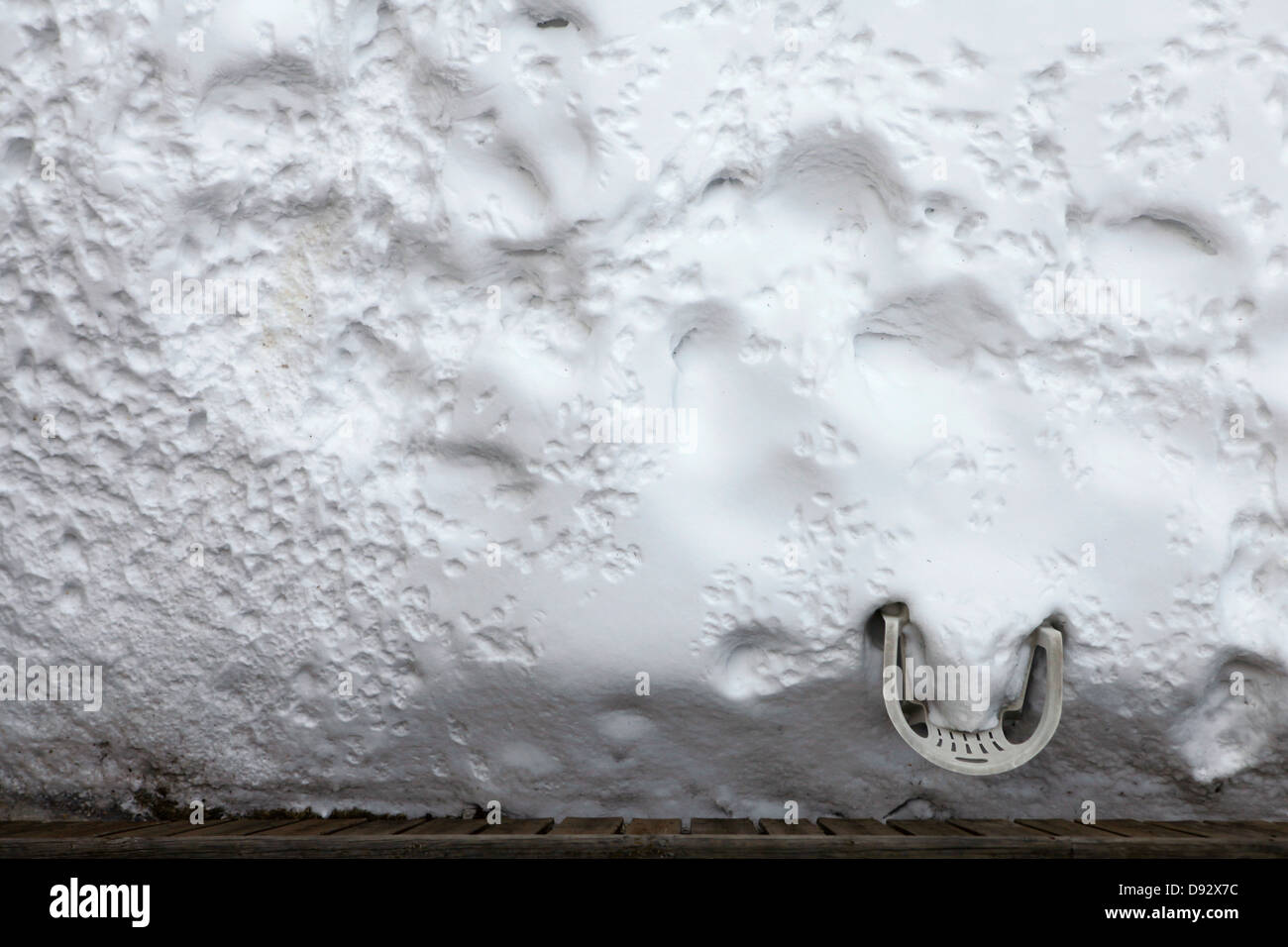Un prato di plastica sedia sepolto nella neve in un cortile Foto Stock