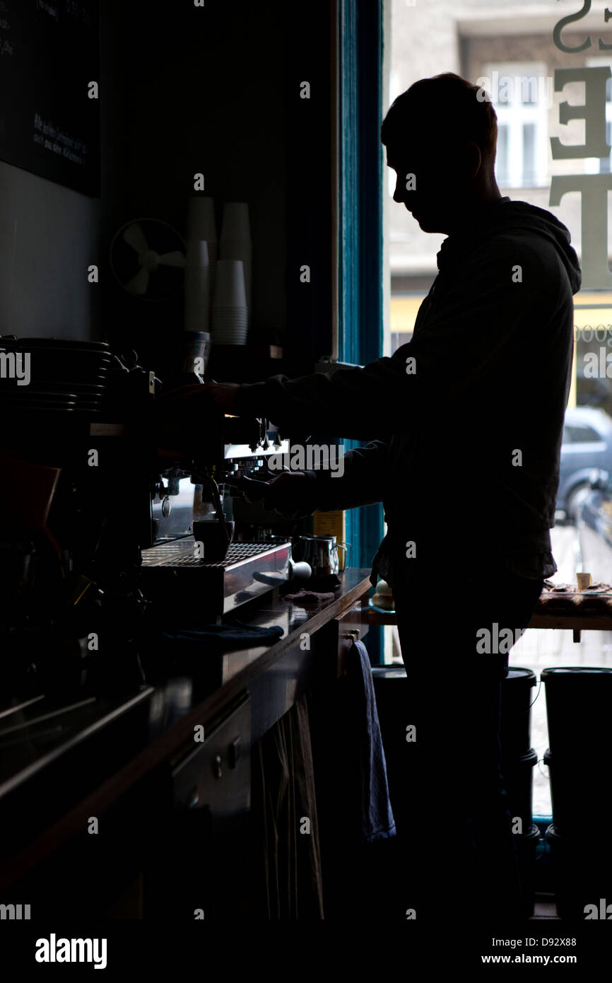 Un barista facendo espresso a una macchina per espresso in un coffee shop Foto Stock