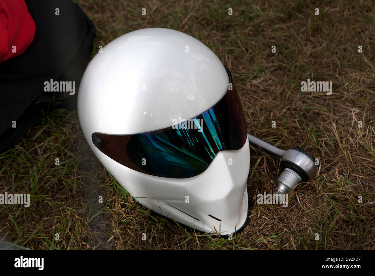 Un moderno ed elegante casco giacente su erba accanto a una chiave a bussola Foto Stock