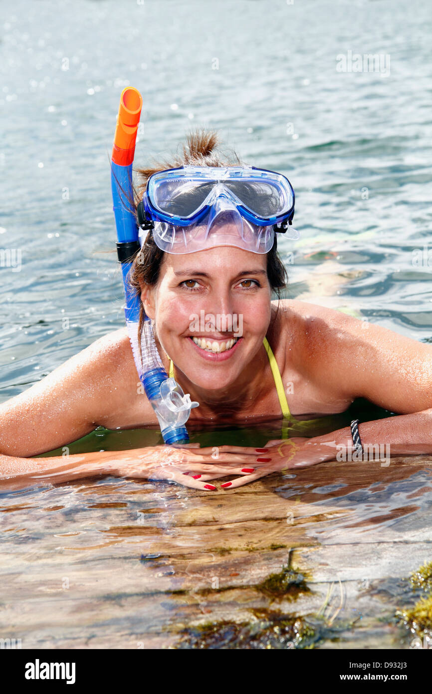 Donna sorridente indossando maschera subacquea Foto Stock