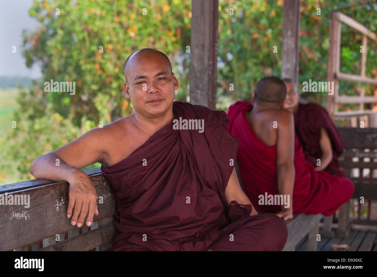 I MONACI BIRMANI utilizza il teak U BEINS ponte per commutare tra il Lago Taungthaman presso sunrise - AMARAPURA, MYANMAR Foto Stock