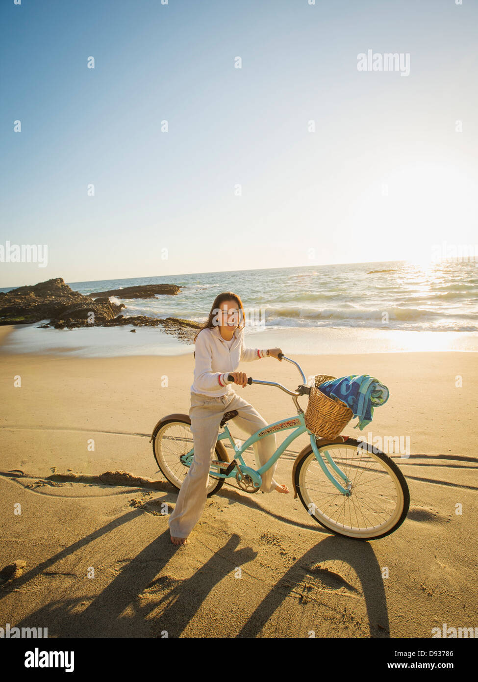 Razza mista donna Bicicletta Equitazione sulla spiaggia Foto Stock