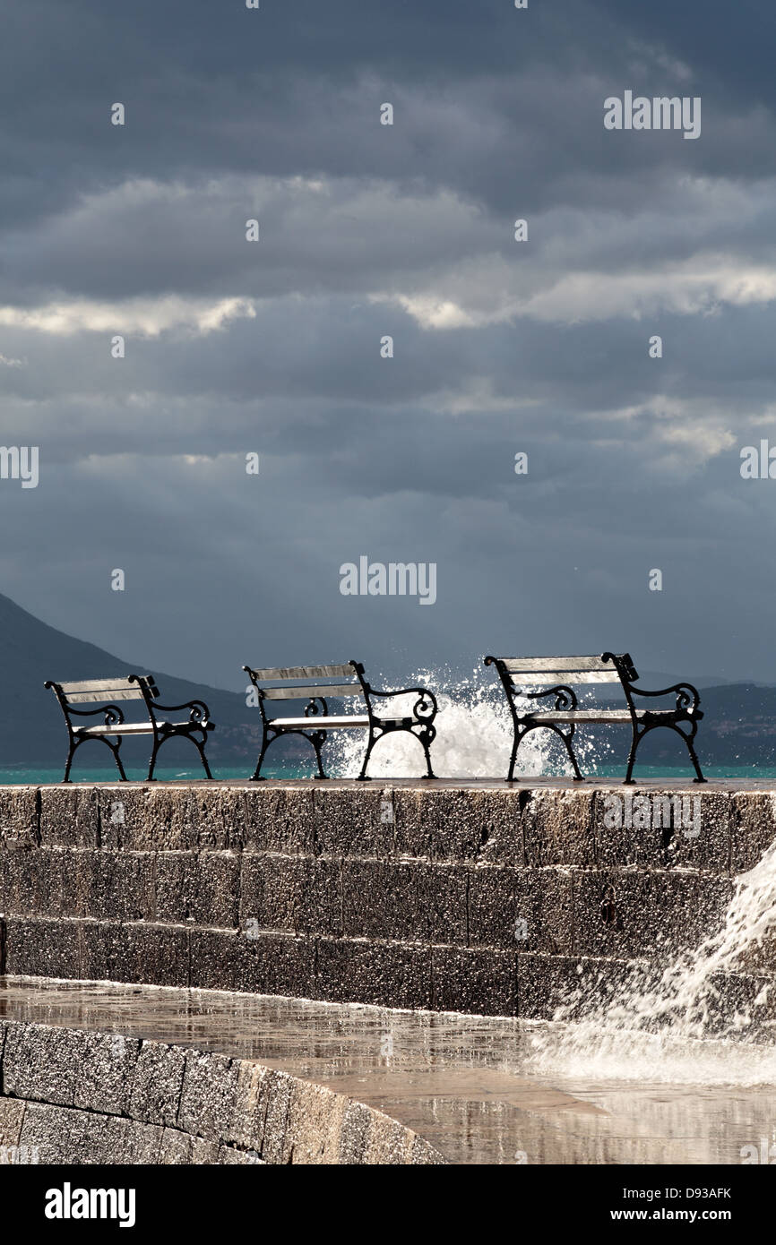 Panchine di maltempo con un cielo scuro e raggi di sole Foto Stock