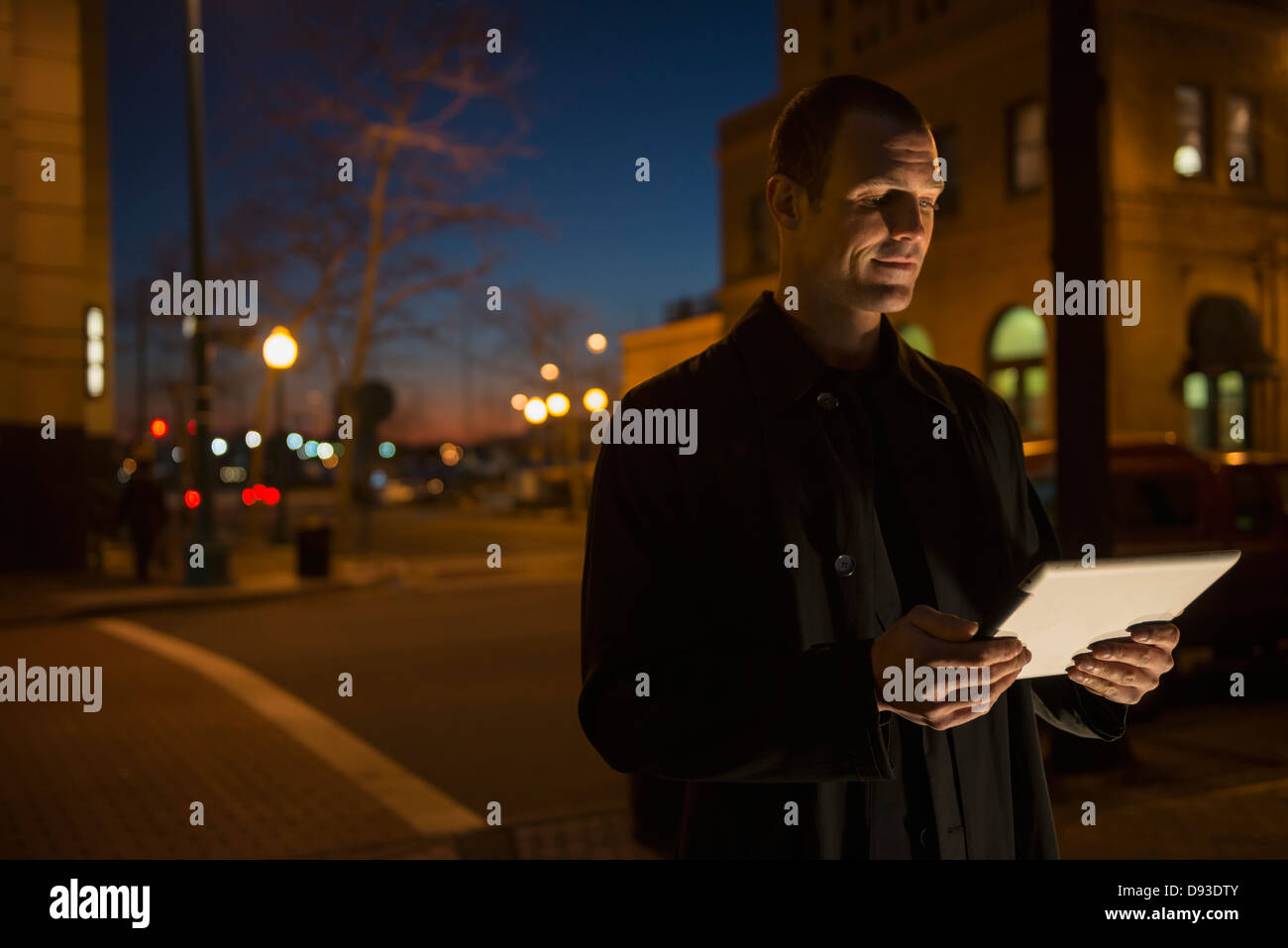 Uomo caucasico utilizzando computer tavoletta su una strada di città Foto Stock
