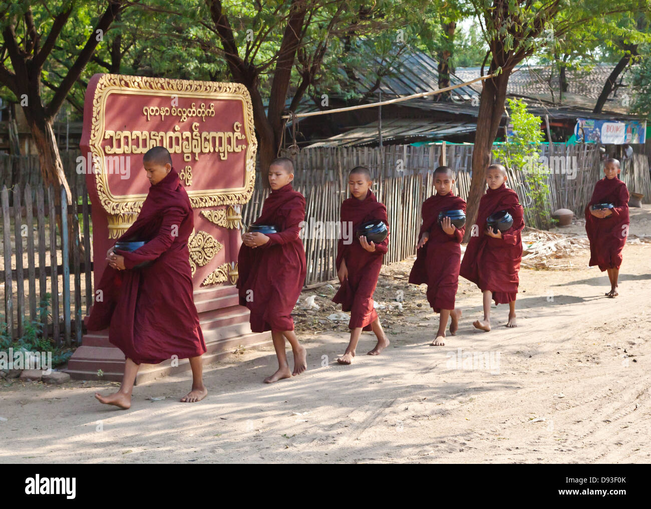 Giovani monaci portano la loro offerta bocce a un tempio - BAGAN, MYANMAR Foto Stock