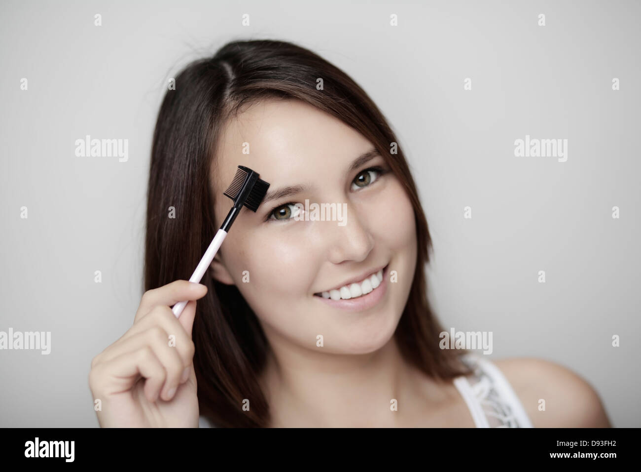 Giovane donna con un occhio brow e ancorare groomer con un grande sorriso sul suo viso Foto Stock