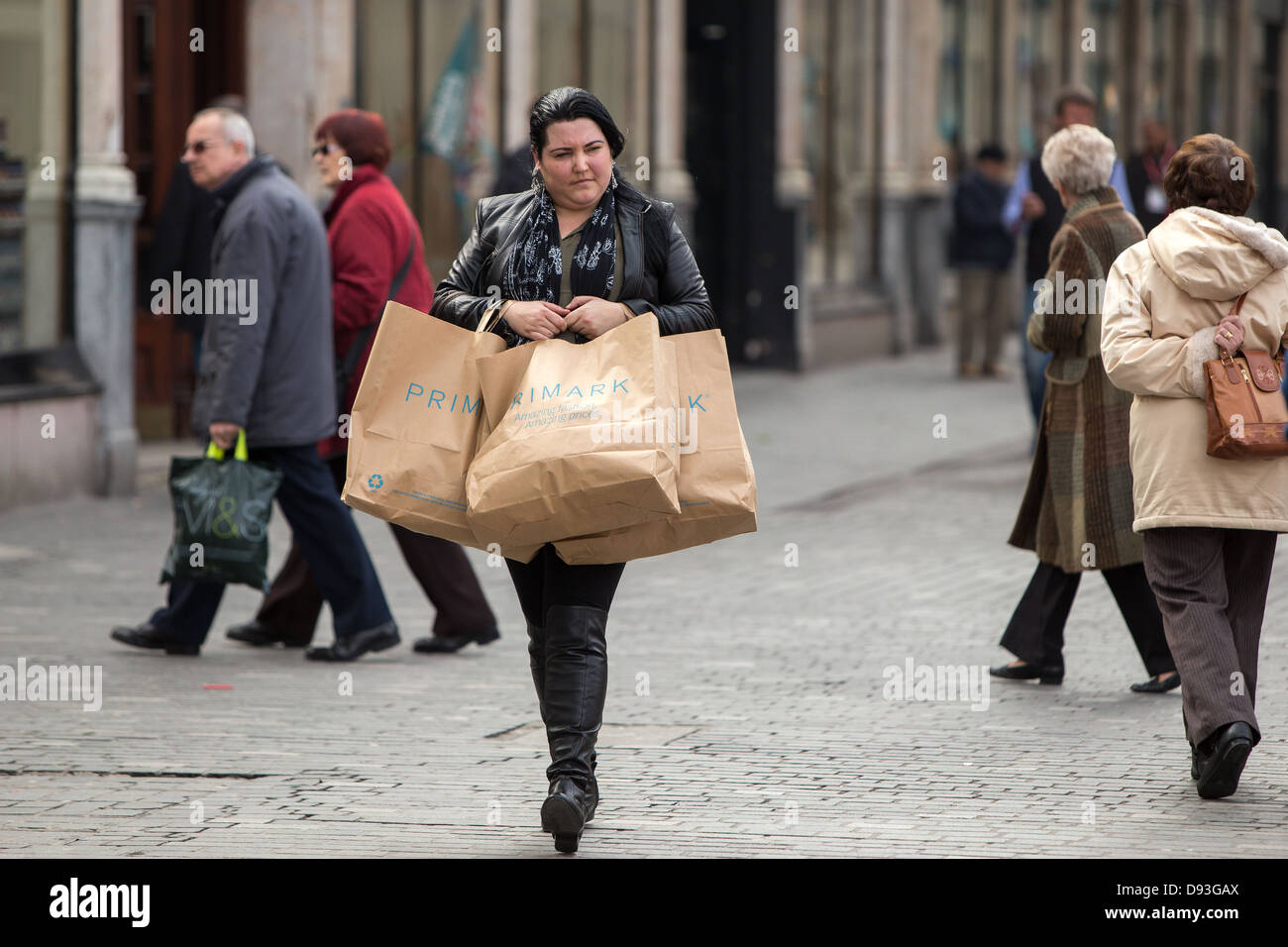 Una donna cammina attraverso il centro di Liverpool che trasportano Primark borse per lo shopping Foto Stock