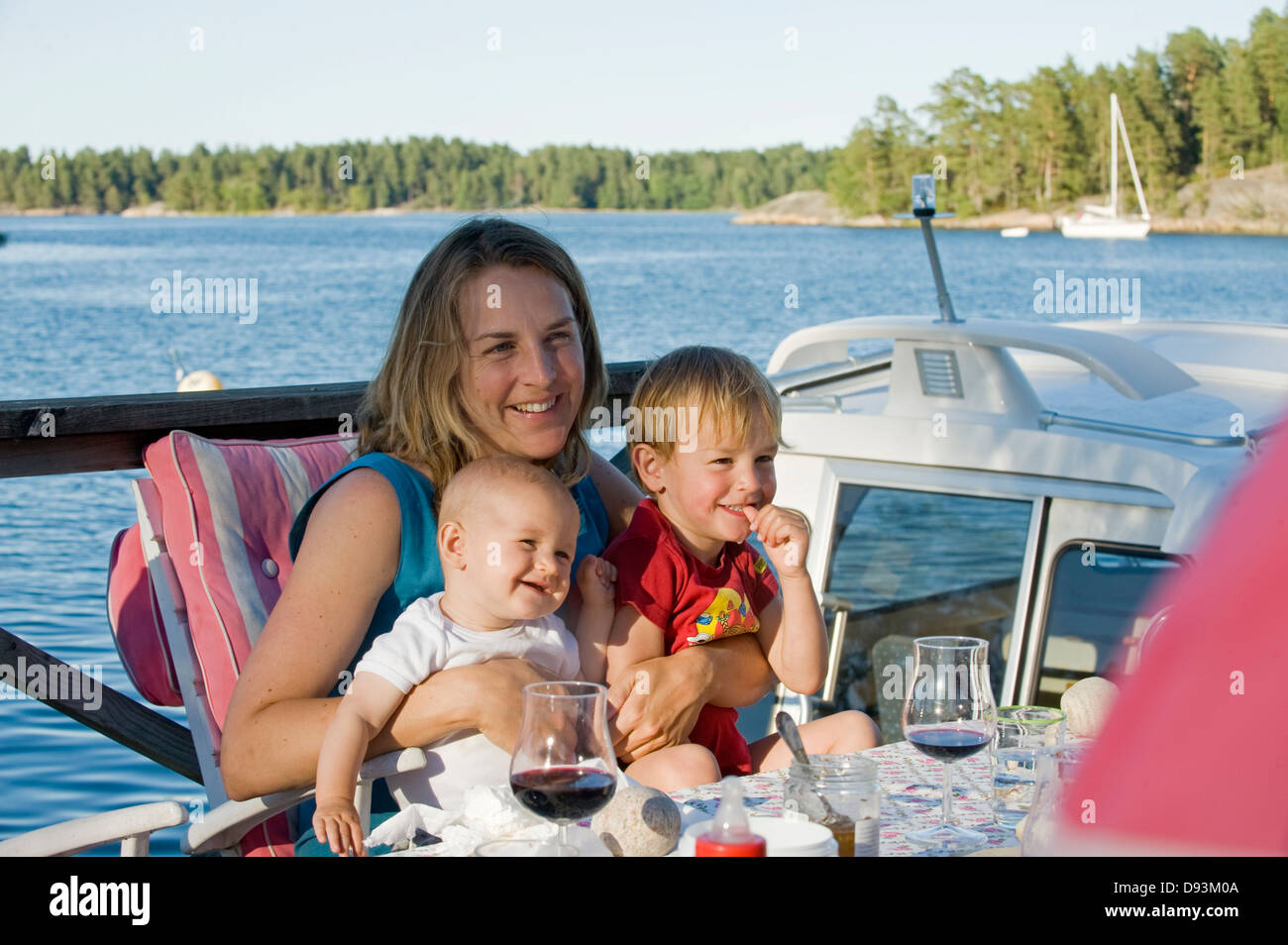 Donna con due bambini di mangiare all'aperto, Svezia. Foto Stock