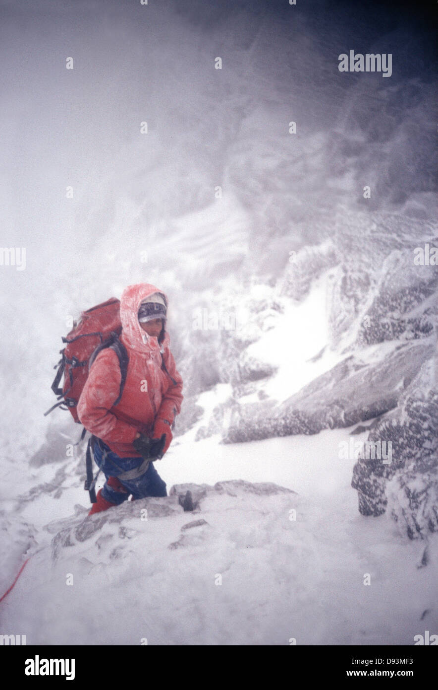 Persona che cammina su roccia ricoperte di neve, vista laterale Foto Stock