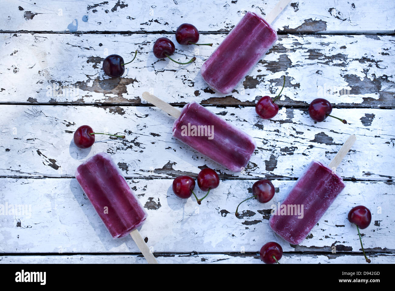 4 cherry popsicles e ciliegie fresche Tavolo picnic Foto Stock